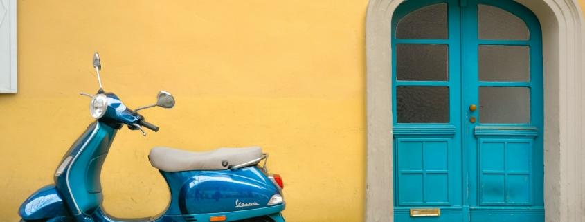 Instituut voor Zakelijke Mediation - Blauwe scooter voor een okergele muur met een blauwe deur