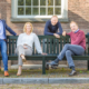 Instituut voor Zakelijke Mediation -team op een houten bank voor een oud gebouw